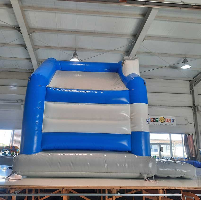 Aufblasbare Hüpfburg in Blau Weiß Grau in einer Halle von der Seite