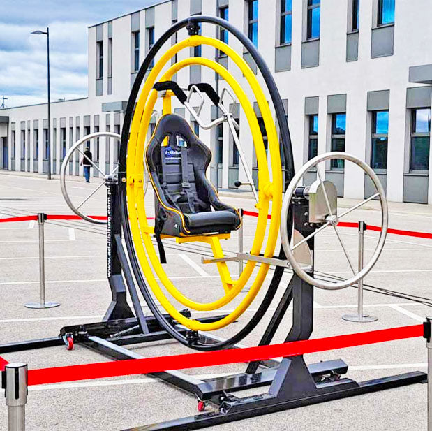 Aerotrim in Gelb-Schwarz gehalten mit zwei Antriebsraedern mit einem Absperrband rundherum vor einem großen Gebaeude