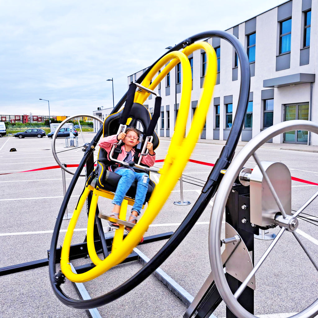 Ein Kind in einem Sitz eines Aerotrim zum mieten der sich gerade bewegt.