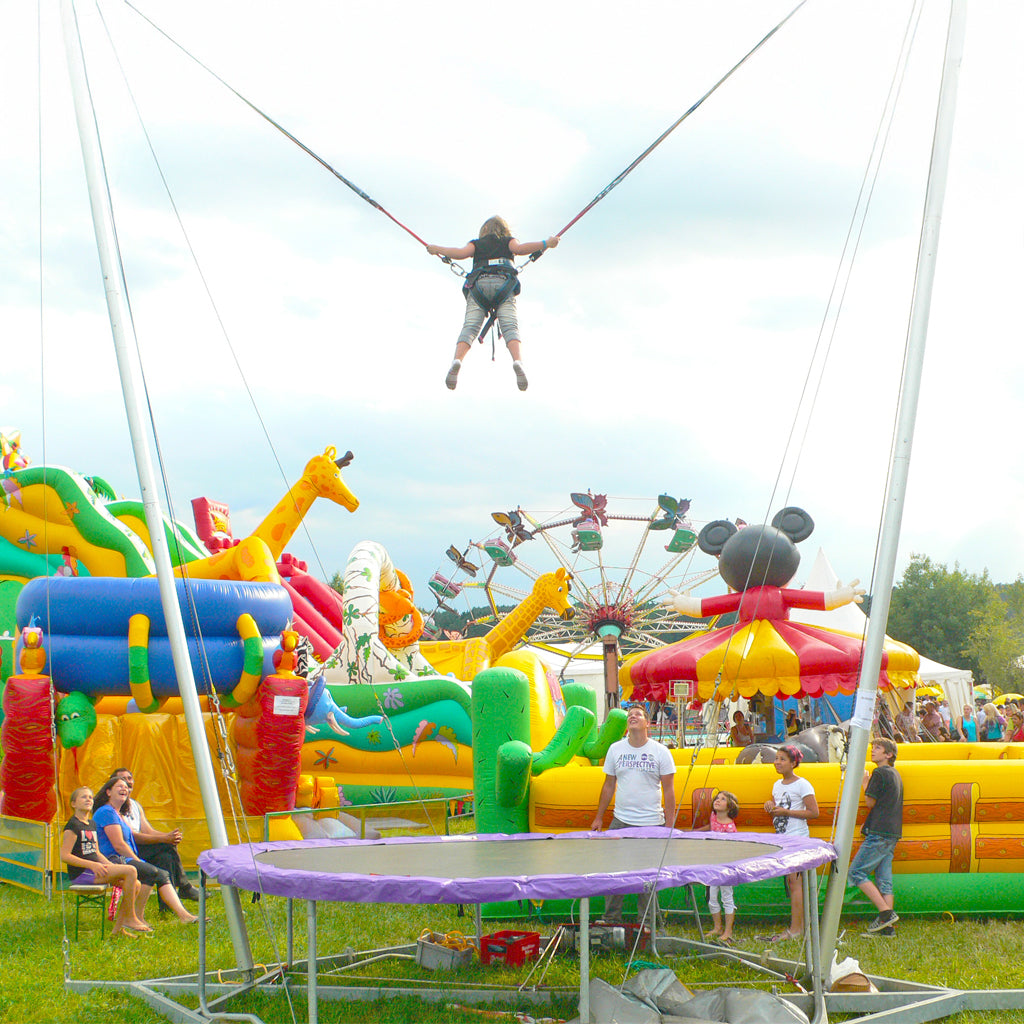 Ein Kind springt an einem Single Bungee Trampolin.