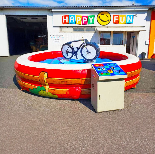 Farbenfrohes Fahrrad Rodeo auf einem Betonplatz vor einer Halle mit einem Steuerpult