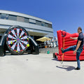 Ein Mann beim schiessen auf ein grosses Fussball-Dart.