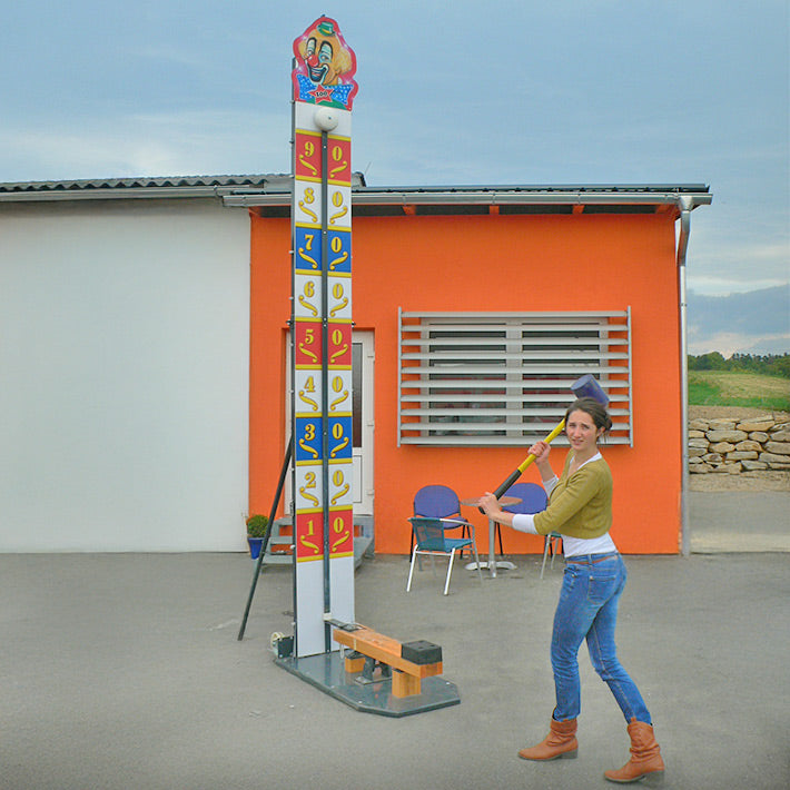 Eine Frau mit einem grossen Hammer beim Hau den Lukas Clown.