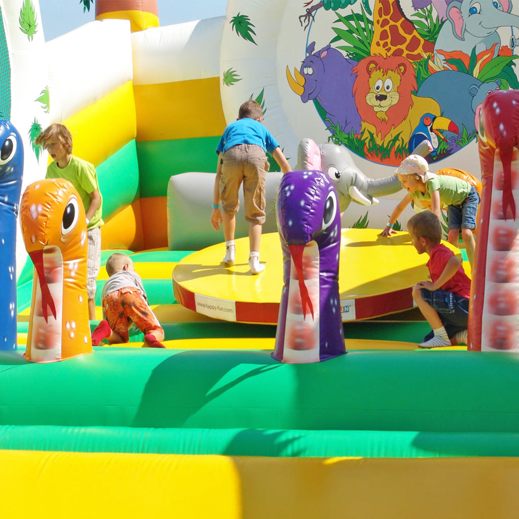 Kinder spielen in einer Hüpfburg auf einer Drehbühne.