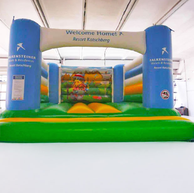Farbenfrohe Hüpfburg in Weiß-Blau-Gelb-Grün gehalten in einer Halle