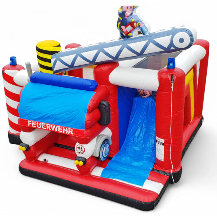 Eine Feuerwehr Hüpfburg, mit Rutsche, aufblasbaren Kran mit Feuerwehrmann über den Einstieg, in kräftigen rot-weißen Farben.