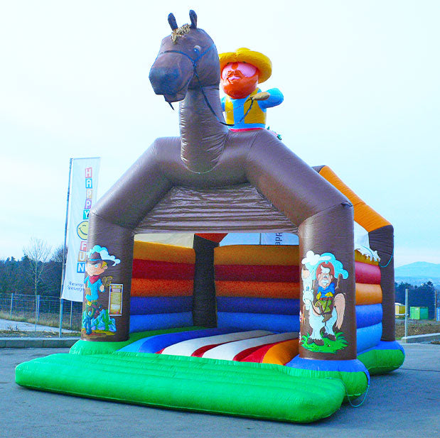 Pferde Huepfburg mit Figuren auf den Saeulen und einem grossen Cowboy auf dem Dach