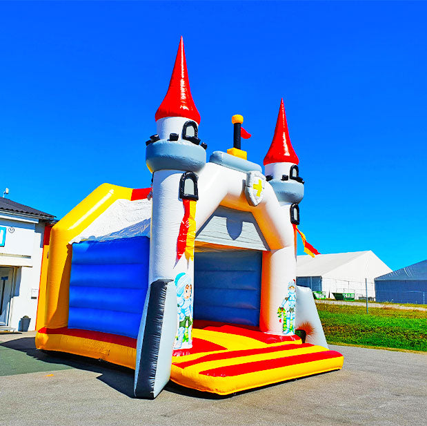Aufblasbare Farbenfrohe Huepfburg in Form einer Ritterburg mit Dach und Tuermen