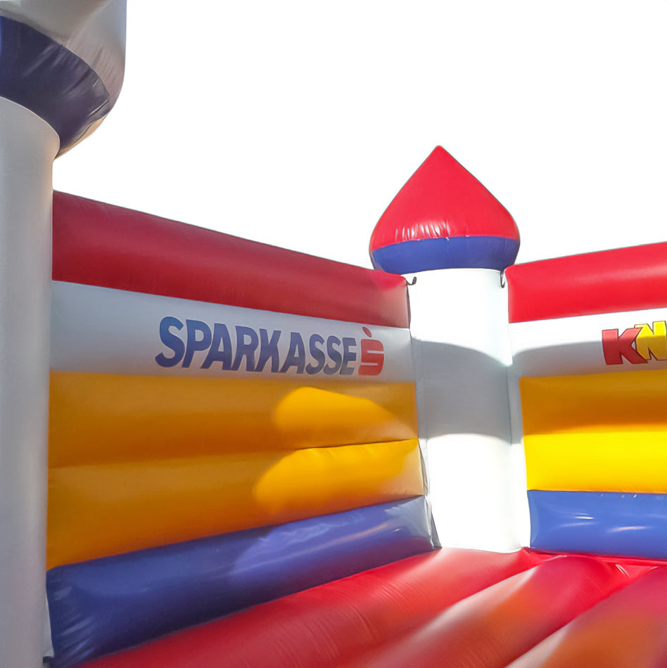 Detailansicht der farbenfrohen KNAX-Hüpfburg mit Sparkasse-Logo auf den seitlichen Luftkammern