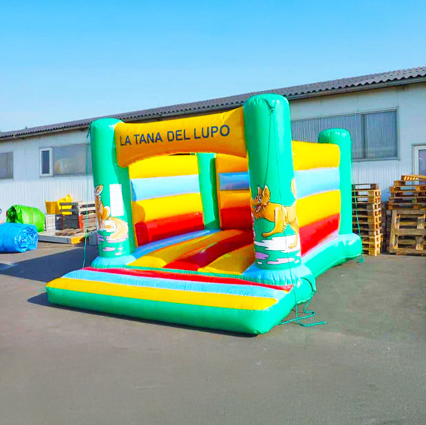 Hüpfburg in fröhlichen Farben neben Paletten auf einem Betonplatz