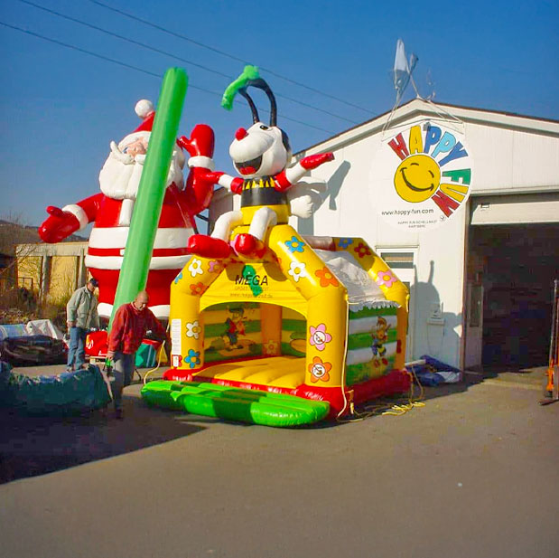 Hüpfburg mit einer Biene auf dem Dach neben einem Weihnachtsmann