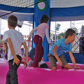 Froehliche Kinder in einer aufblasbaren Farbenfrohen Huepfburg.