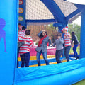 Personen in Rot-Weissen T-Shirts in einer Huepfburg mit Netzwaenden.