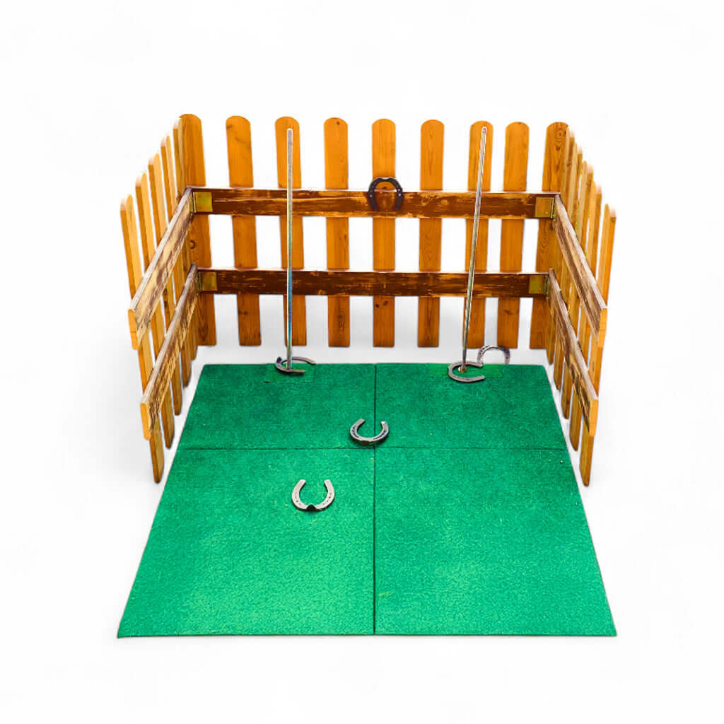 Ein Spiel umrandet mit einem Holzzaun, sechs Hufeisen und 2 Stangen.