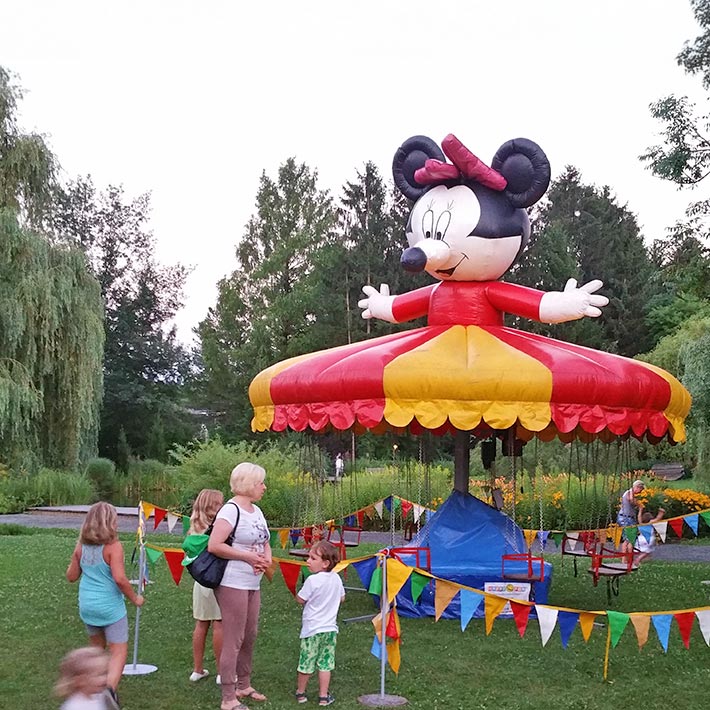 Abgesperrtes Kettenflieger-Karussell auf einer gruenen Wiese.