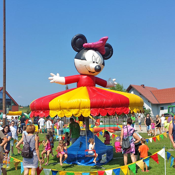 Grosses Kettenflieger-Karussell mit zehn Sitzen im freien rundherum viele Kinder und Erwachsene.