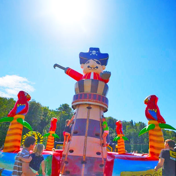 Aufblasbarer Farbenfroher Kletterturm mit Kindern die darauf klettern und Eltern die zusehen