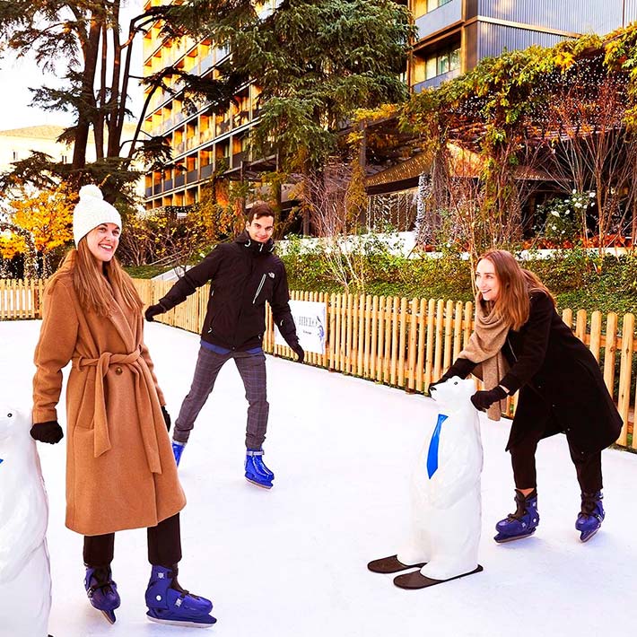 Zwei Frauen und ein Mann laufen Schlittschuh.