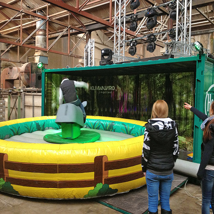 Eine Person auf einem Nashorn Rodeo und zwei Damen die zusehen.