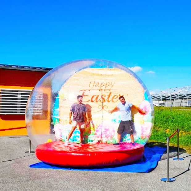 Zwei Jungs in einer Transparenten Fotokugel mit rotem Boden und einem Osterbild an der Rueckseite