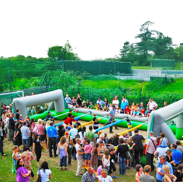 Viele Menschen rund um einen aufblasbaren Riesenwuzzler mit Spielern