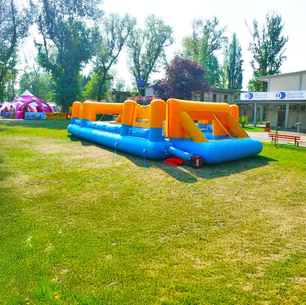 Aufblasbarer Riesenwuzzler mit Netztoren auf einer Wiese vor einem rosa Zelt
