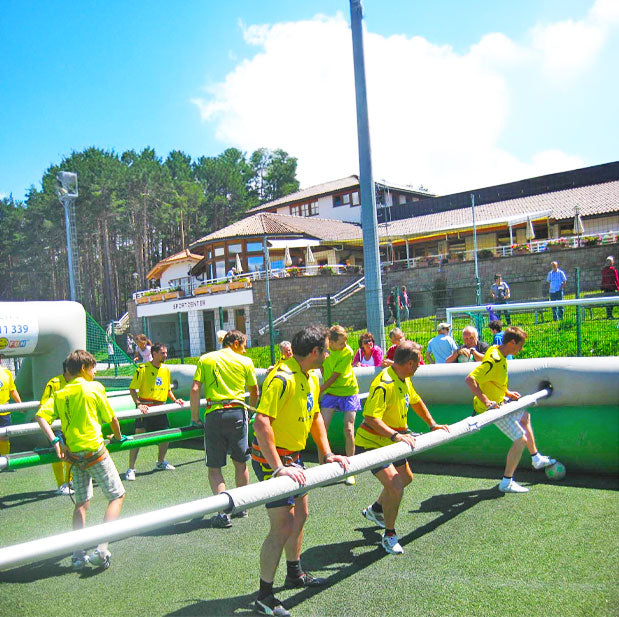 Erwachsene Maenner bei einem Riesenwuzzler Turnier im Freien bei Sonnenschein