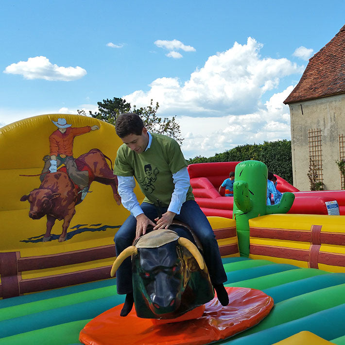 Ein Mann auf einem mechanischen Stier mit Fallbecken.