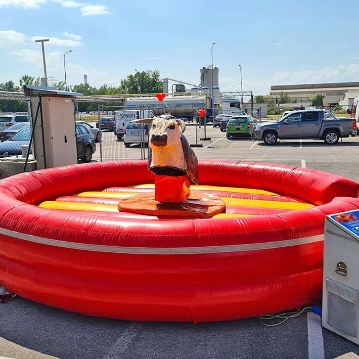 Rodeo Bulle mit einem Rot-Gelben Fallbecken auf einem Parkplatz.
