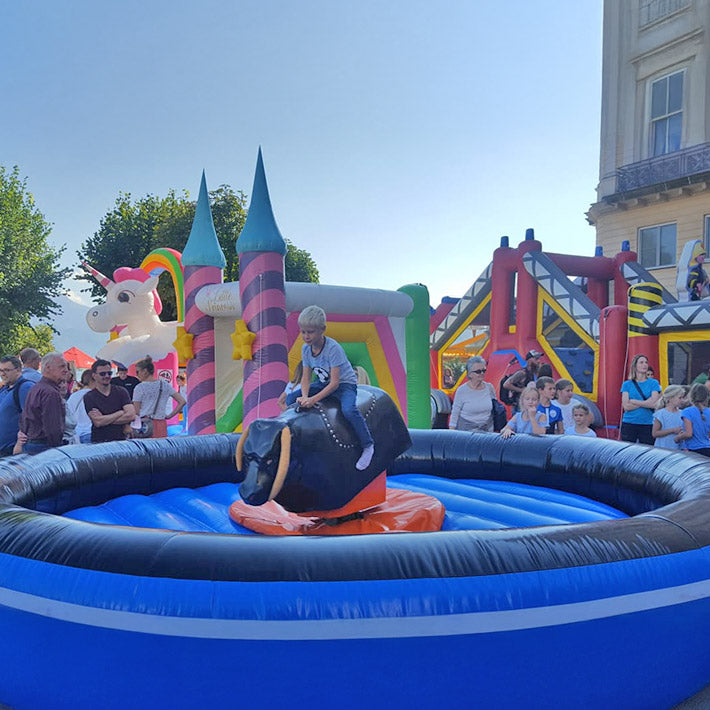 Kleiner Junge auf einem Rodeo mit blauem Fallbecken.