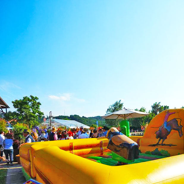 Aufblasbarer Rodeo mit einem Bullen in der Mitte und rundherum sehr viele Menschen