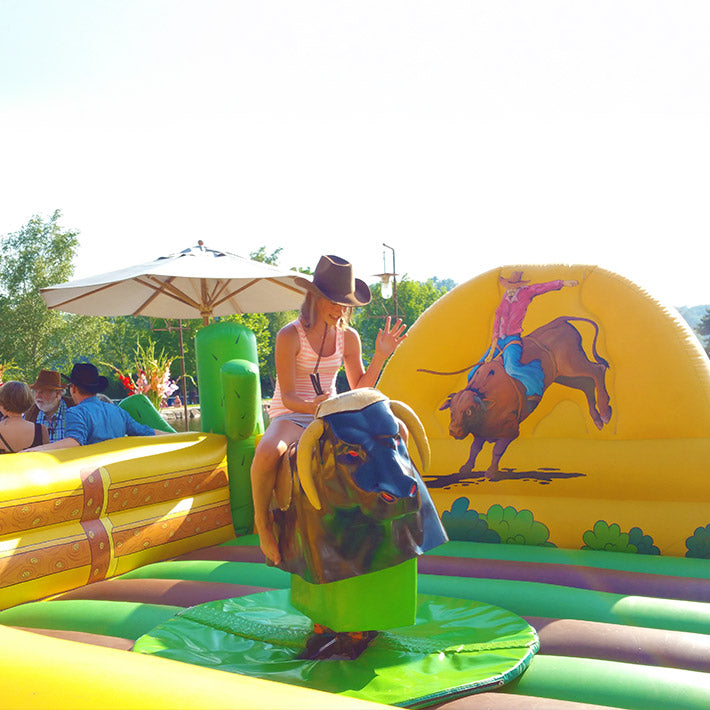 Junges Mädchen reitet auf einen Bullriding Stier.