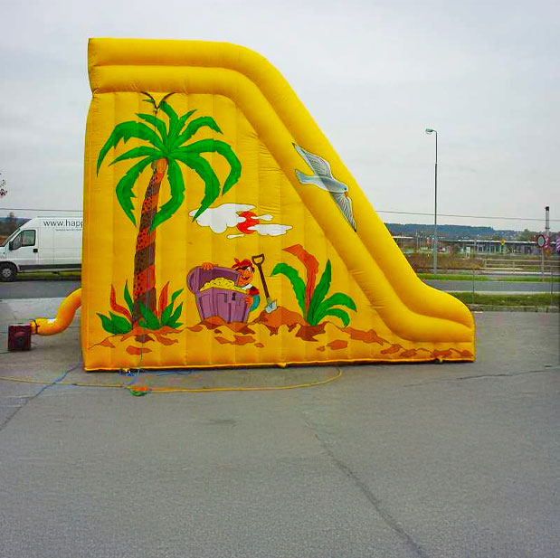 Farbenfrohe Hüpfburg von der Seite mit einem Piraten mit Gold, einer Möwe und einer Palme darauf
