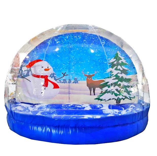 Aufblasbare Transparente Schneekugel zum mieten mit einem Schneemann der eine Rote Muetze und einen Roten Schal traegt, einem Reh und einem Tannenbaum mit Schnee drauf.