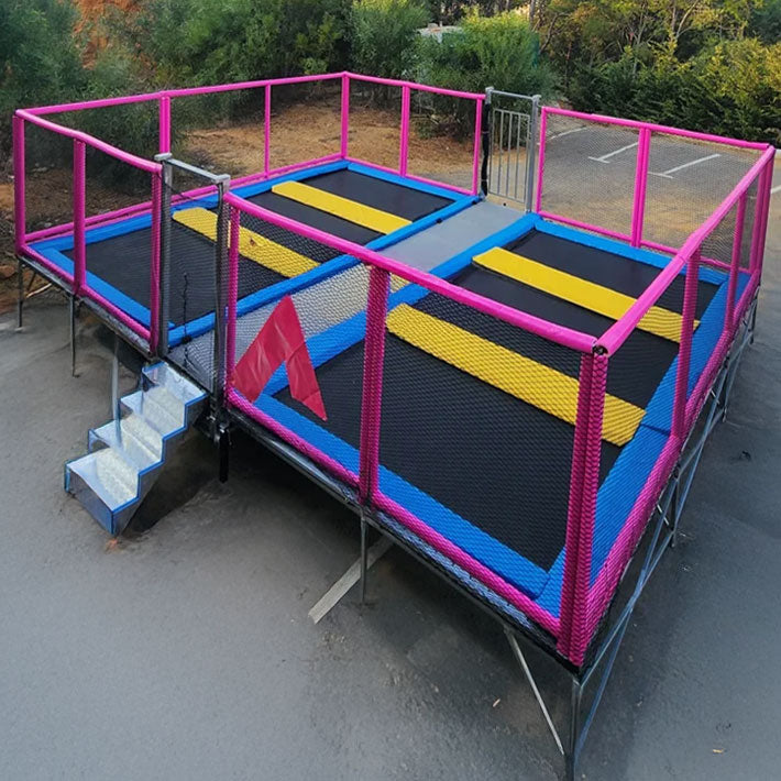 Mobile 6er Trampolin Anlage zum mieten in leuchtenden Farben im freien.