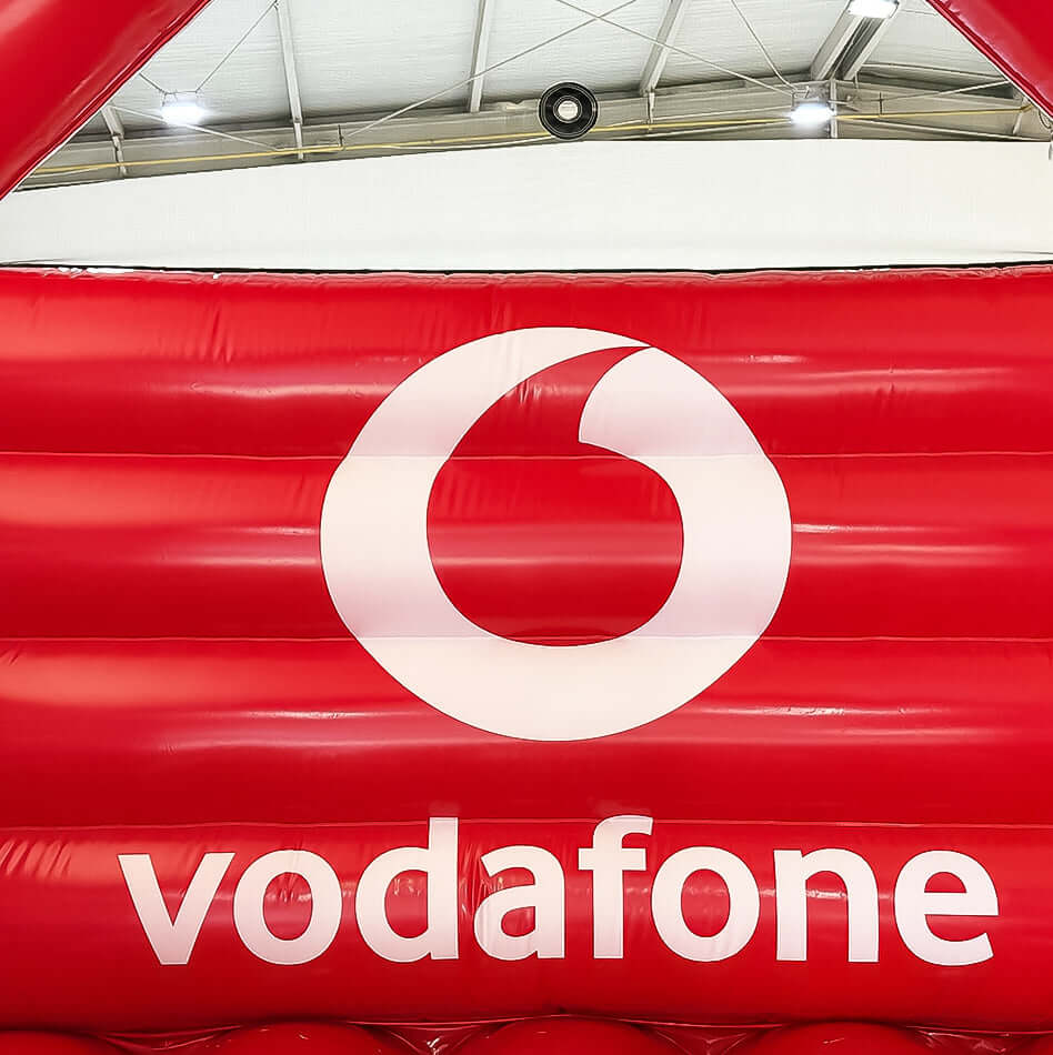 Nahaufnahme des weißen Vodafone-Logos auf rotem Hüpfburg-Material - ideal für gebrandete Events und Firmenauftritte mit hoher Sichtbarkeit.