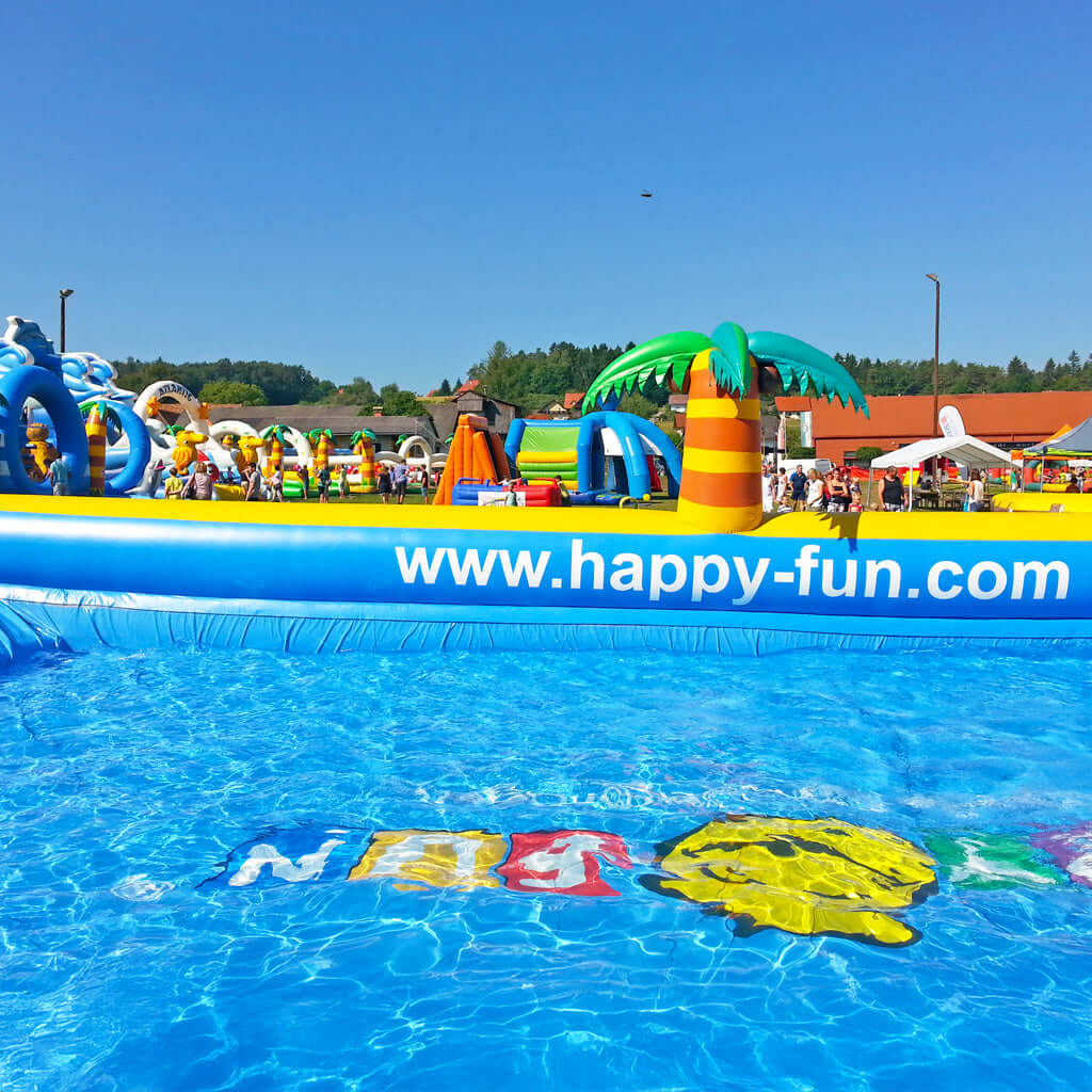 Großes aufblasbares XXL Wasserbecken mit einem smiley im Wasser.