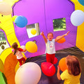 Eine Hüpfburg in der Kinder reingehen können, in der Ballone herumfliegen.