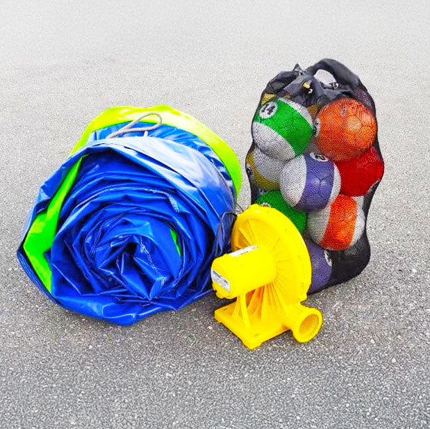 Zusammengelegtes Fussball-Billiard mit einem Netz voller Baelle und einem gelben Geblaese