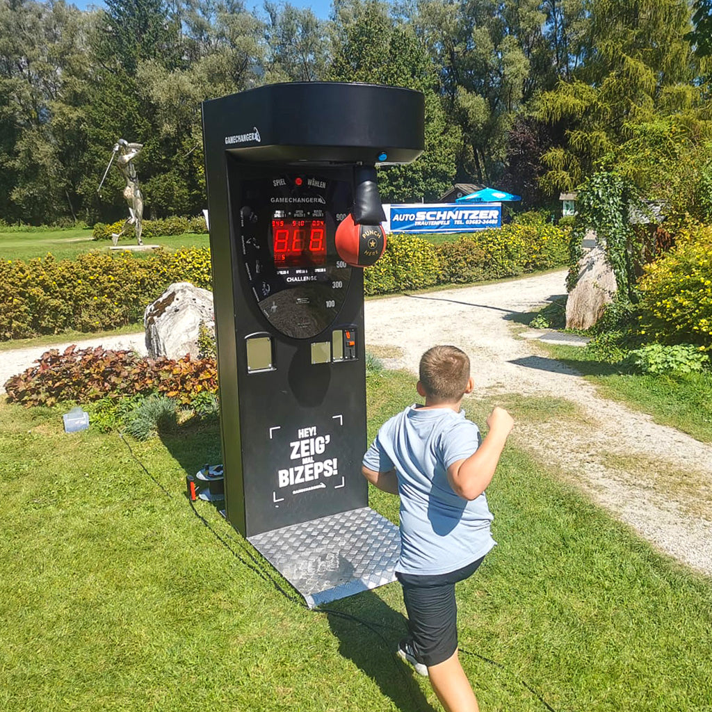 Ein Boxautomat und Junge der darauf einschlagen will.