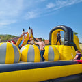 Schwarz-gelbe aufblasbare Hüpfburg mit großen Ballelementen als Hindernisse, für Kinder und Erwachsene.