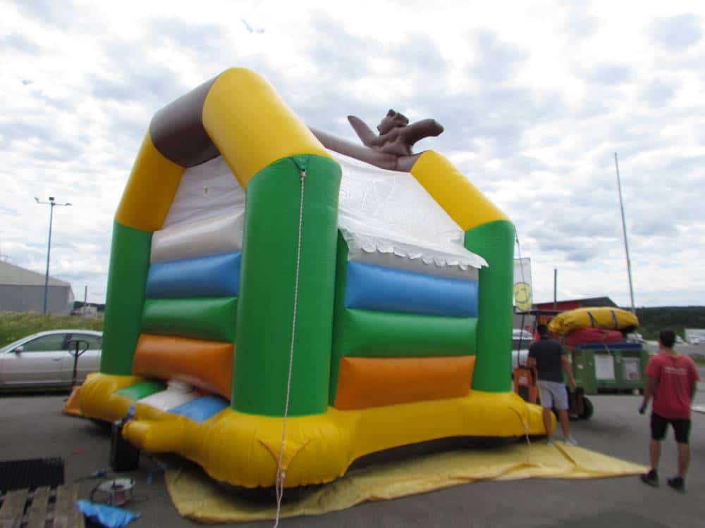 Hüpfburg auf einem Betonplatz von der Seite mit einem Gebläse