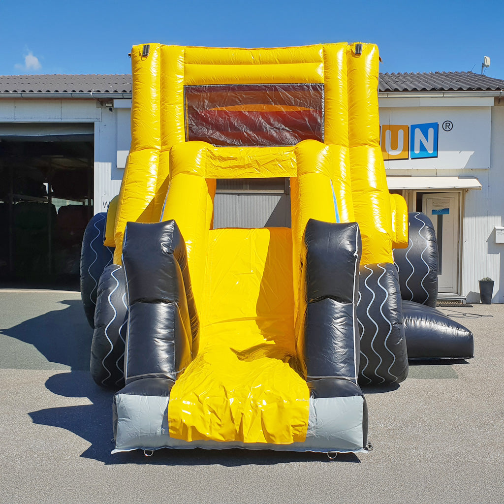 Eine aufblasbare Hüpfburg konstruiert wie ein Bagger in den Farben schwarz und gelb.