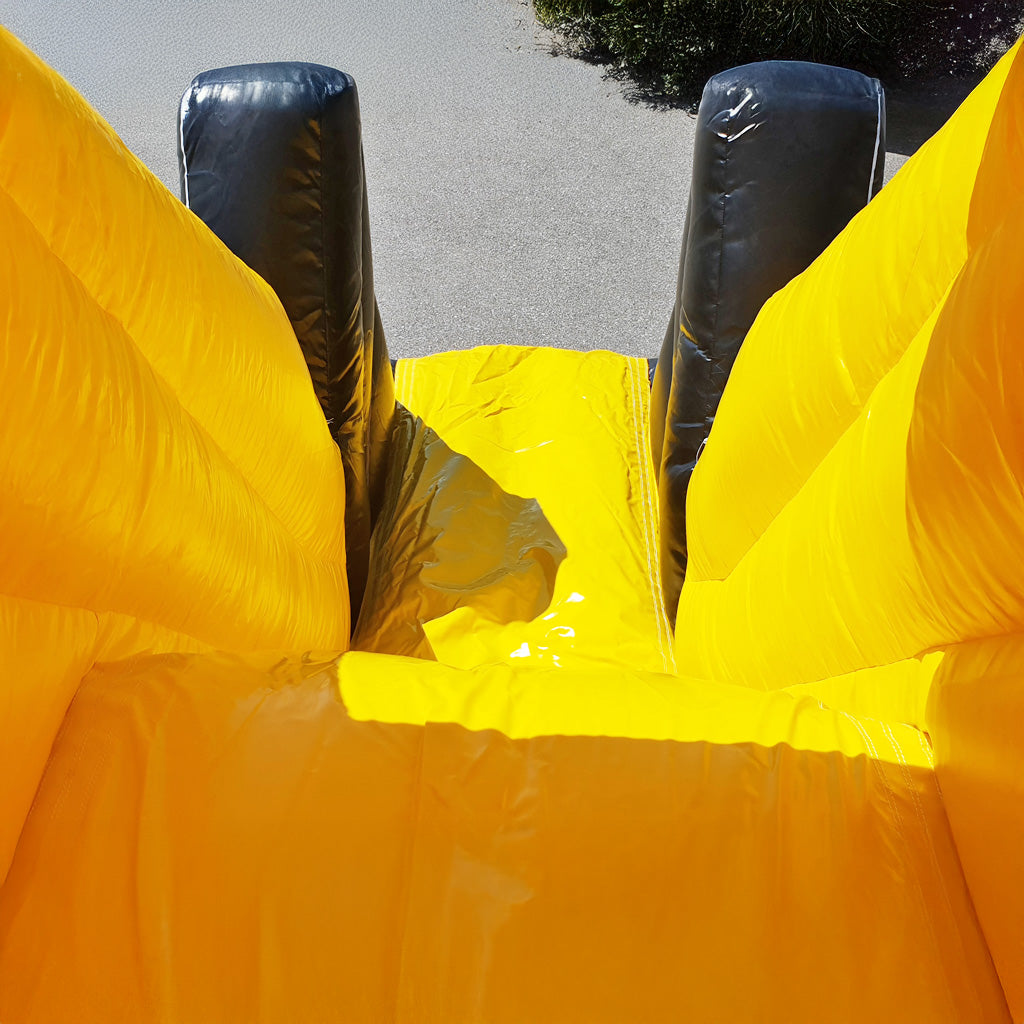 Eine gelbe Rutsche von einer Hüpfburg.