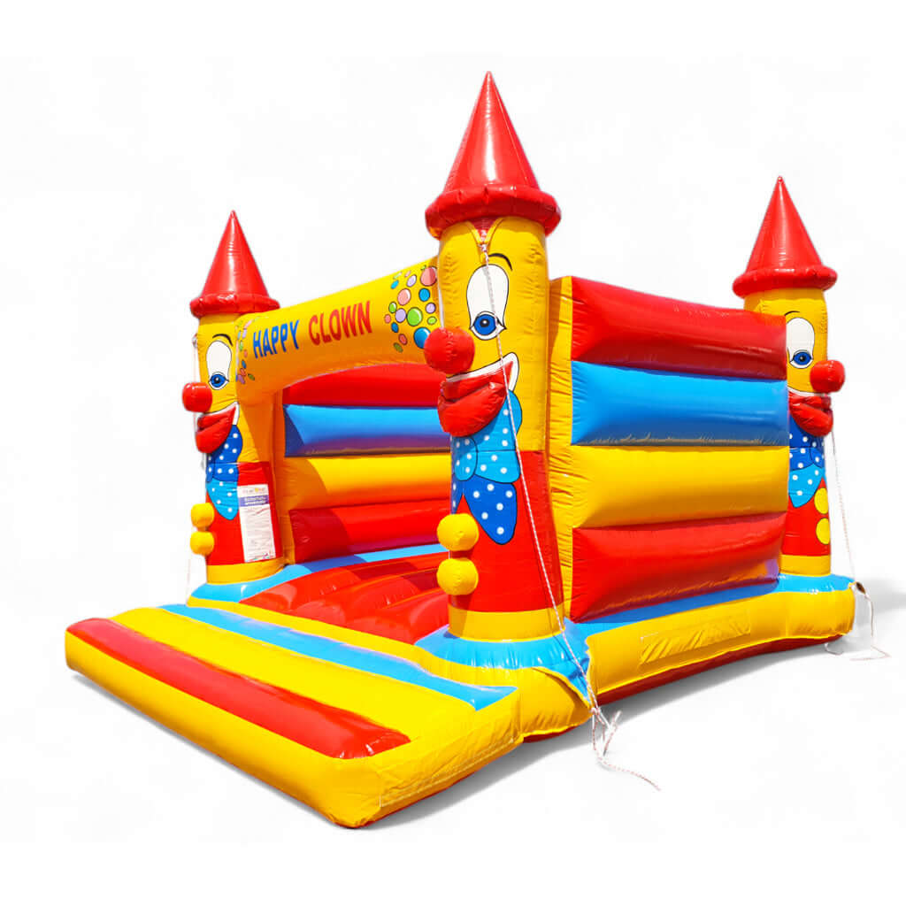 Aufblasbare Hüpfburg mit roten Spitzhüten bunten Wänden und roter Hüpffläche.