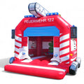 Eine Hüpfburg in Feuerwehroptik mit aufblasbaren Elementen wie einem Kran, Blaulichter, Türen und Reifen.