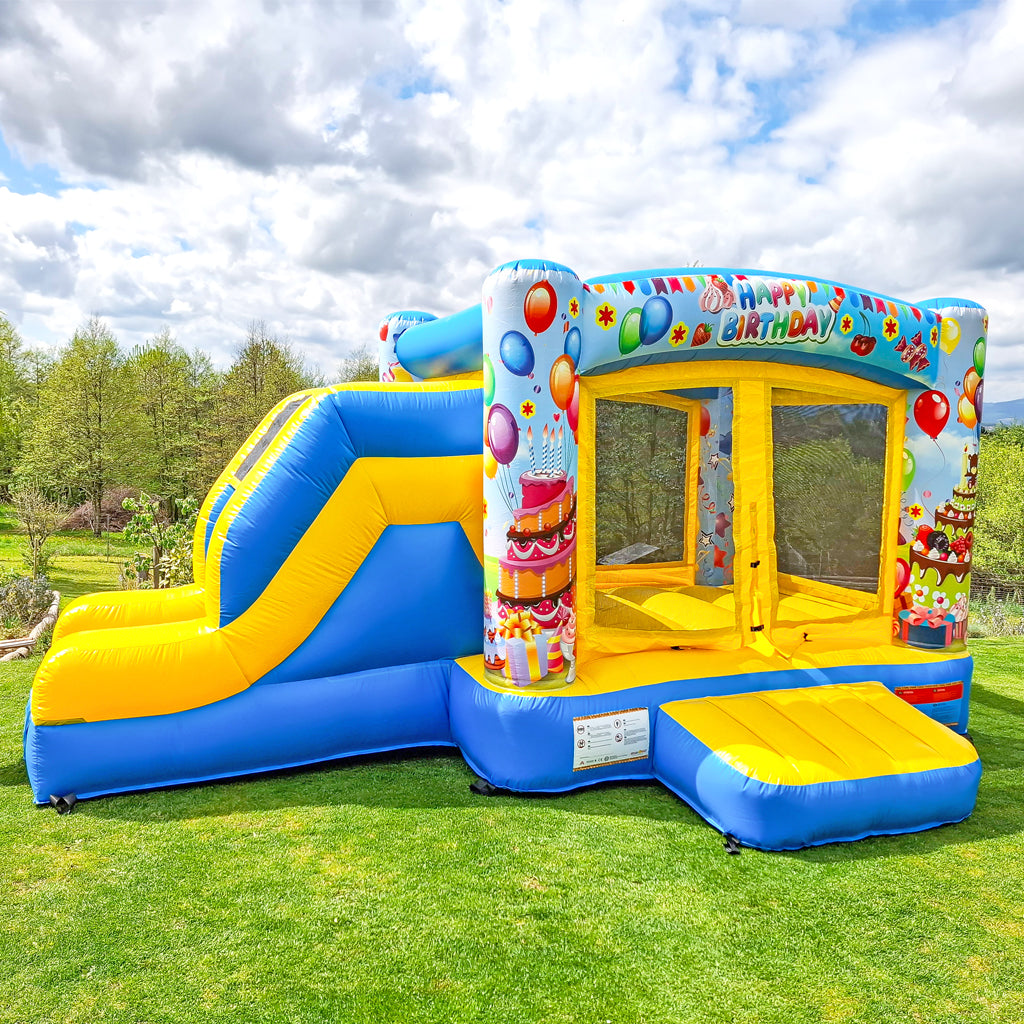 Hüpfburg mit Rutsche, Happy Birtday Aufdruck und viele Ballone.