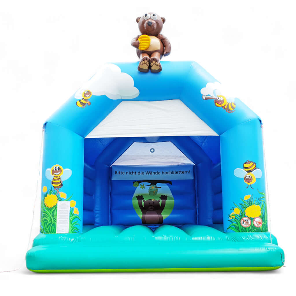 Blaue Hüpfburg mit Gräsern und Bienen auf den Säulen sowie einer grünen Hüpffläche.