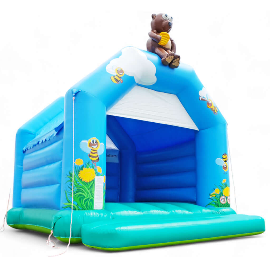 Blaue Hüpfburg mit aufblasbaren Bären sitzend auf dem Torbogen.