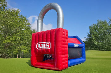 Eine Hüpfburg in Form eines Vorhangschlosses mit Werbung.